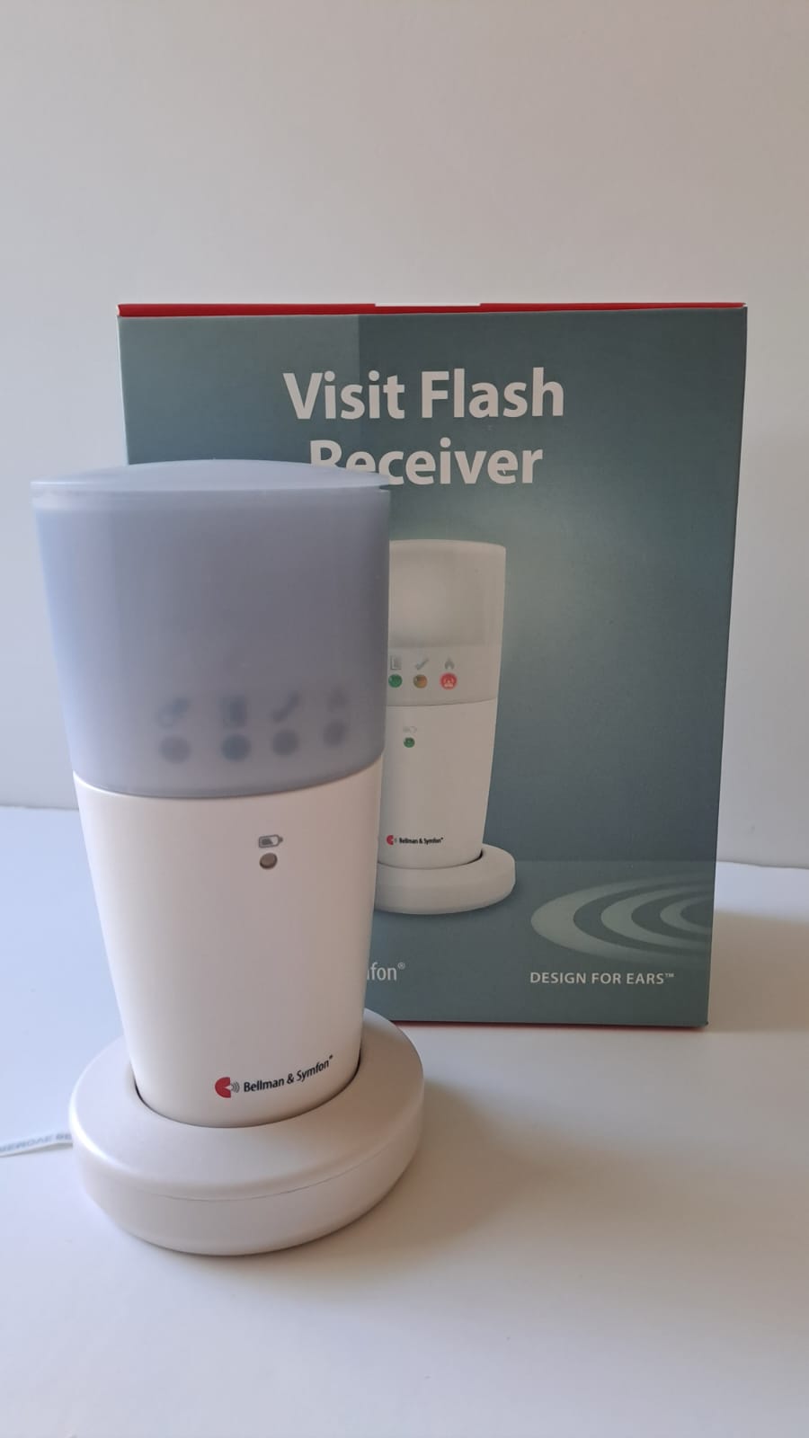 Odbiornik świetlny Visit Flash Receiver – biała lampka z mlecznym kloszem i diodami sygnalizacyjnymi na okrągłej podstawce, za nią opakowanie urządzenia.